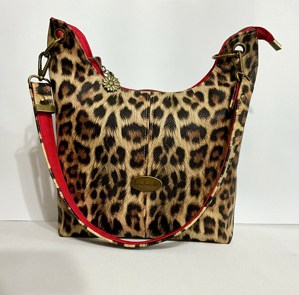 Uptown Swing leopard print shoulder bag with red accented strap, front view